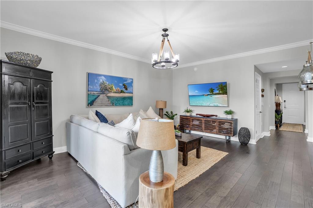 985 Sandpiper Street, Unit I103 Naples, FL 34102 - Photo 3 of 32 a living room with furniture and a chandelier
