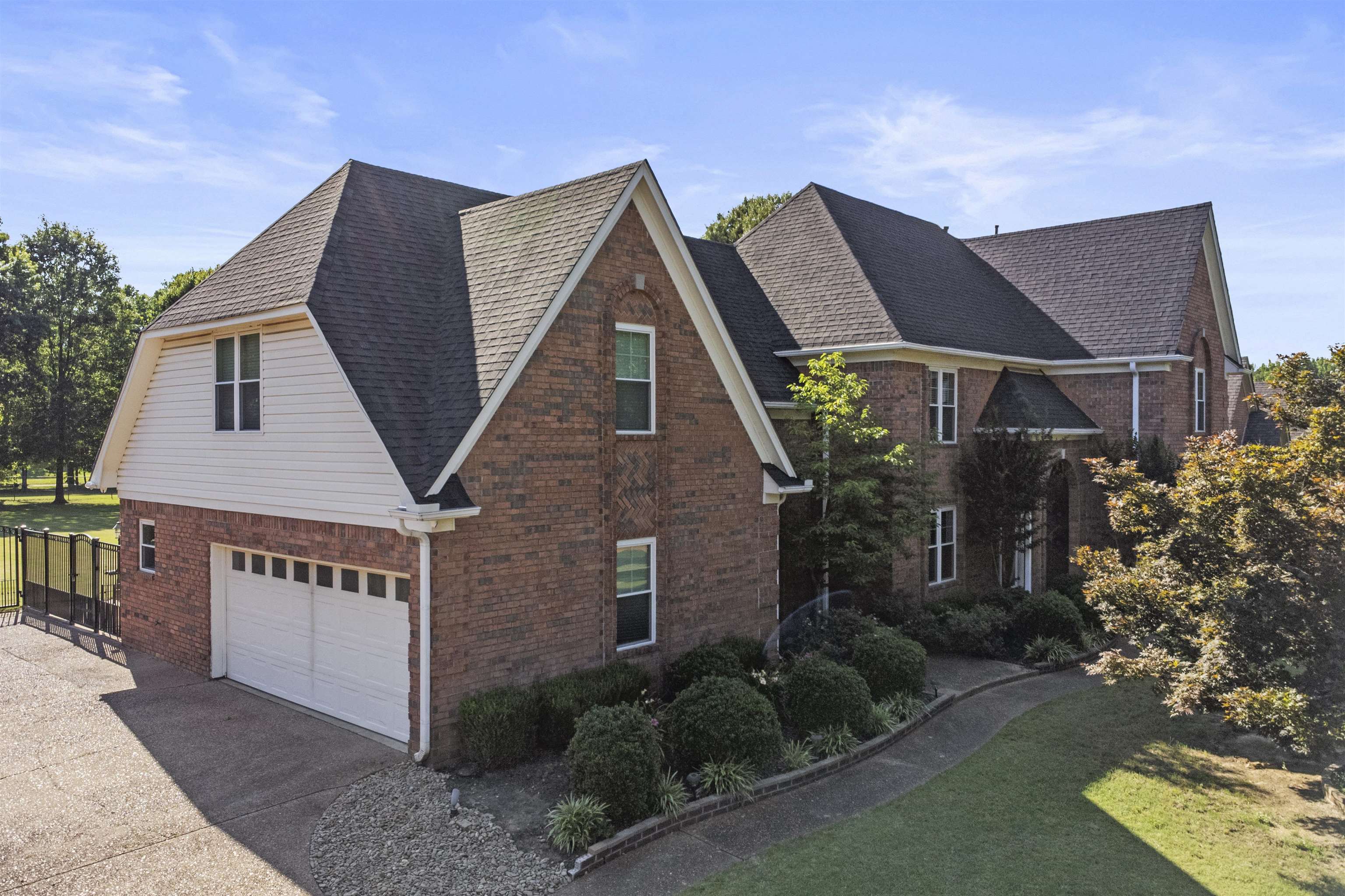 4279 High Plains Road Bartlett, TN 38135 - Photo 1 of 37 Brick exterior with gabled roof lines, attached two-car garage, upper-level dormer, paved driveway, and mature landscaping
