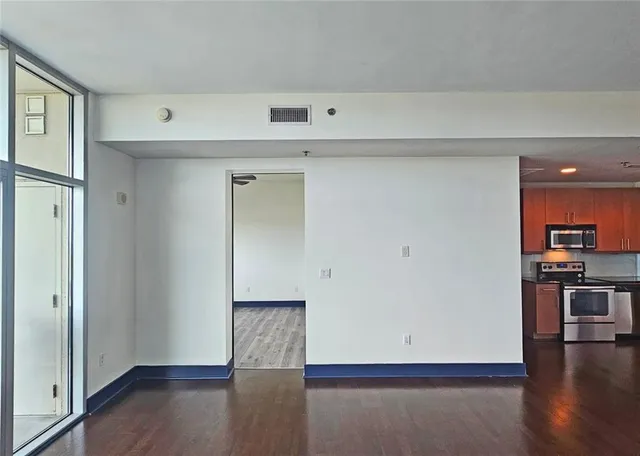 a view of empty room with wooden floor