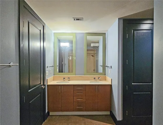a bathroom with a double vanity sink and mirror
