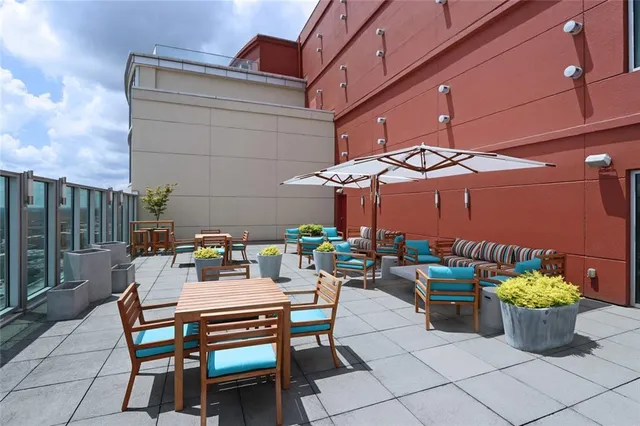 a view of a patio with a dining table and chairs under an umbrella