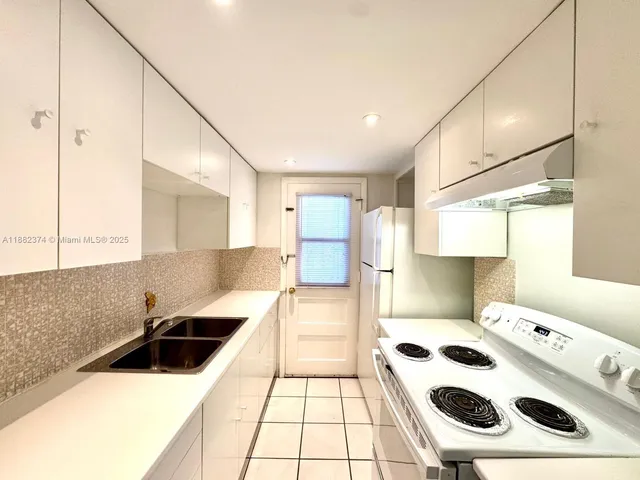 a kitchen with a sink a stove and a refrigerator