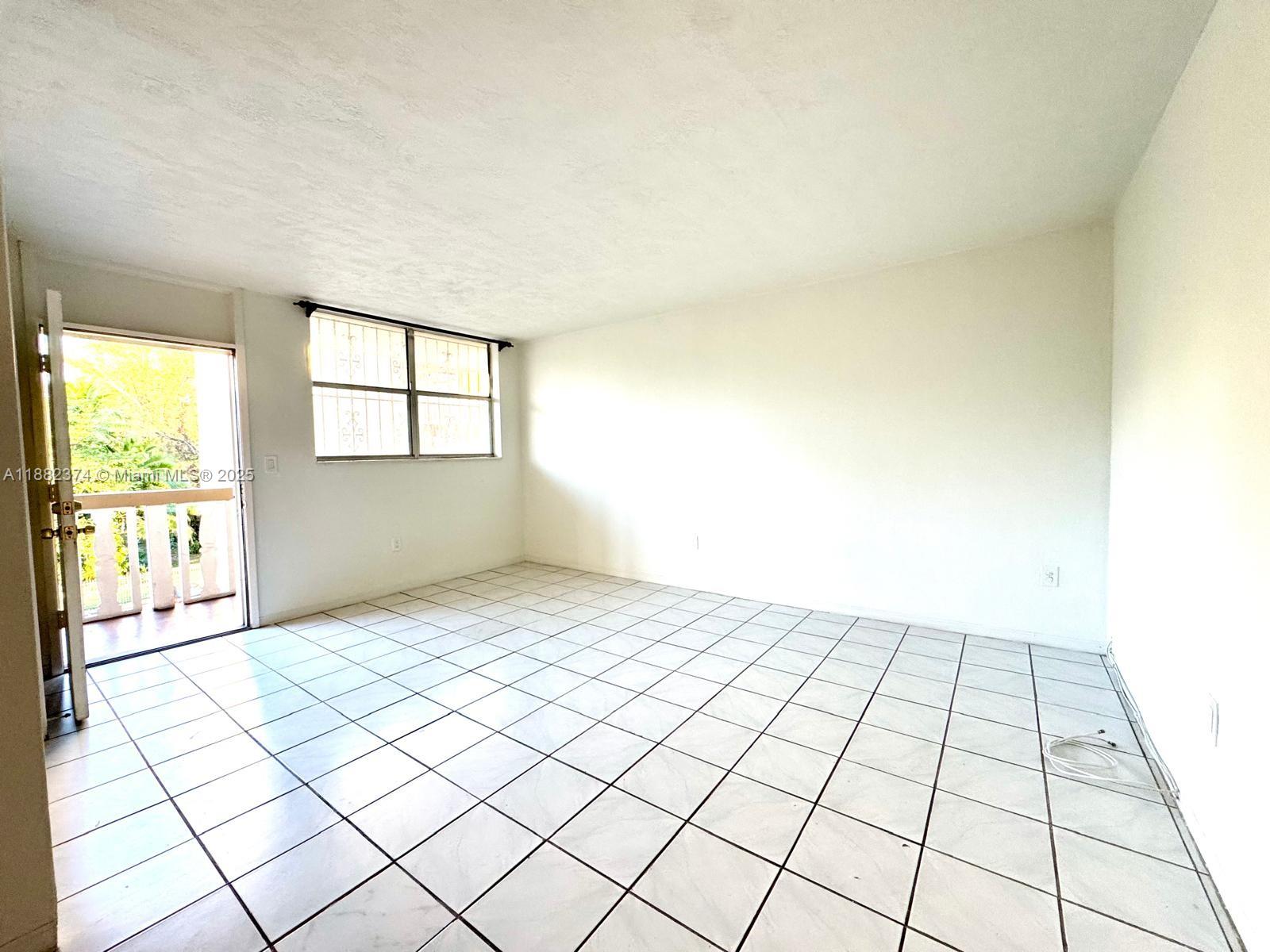 1475 Northeast 125th Terrace, Unit 404B North Miami, FL 33161 - Photo 17 of 22 a view of an empty room and window