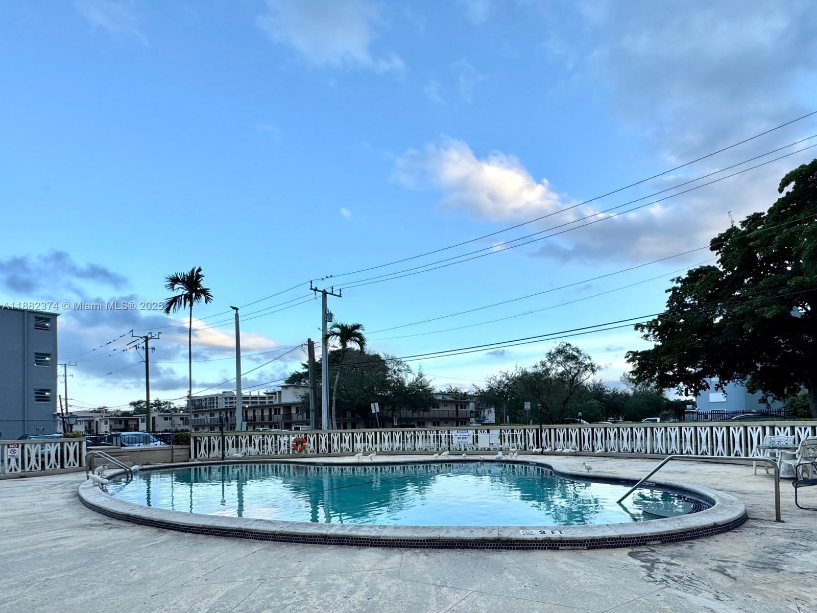 1475 Northeast 125th Terrace, Unit 404B North Miami, FL 33161 - Photo 22 of 22 a view of a swimming pool with a patio
