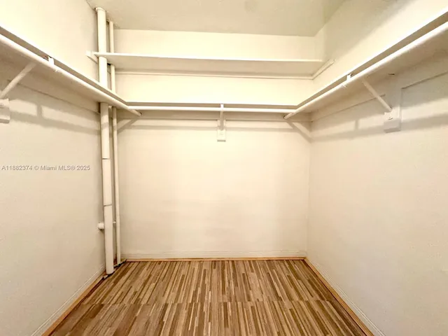 a view of a room with wooden floor and small window