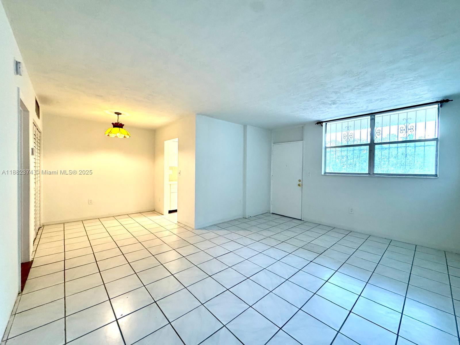 1475 Northeast 125th Terrace, Unit 404B North Miami, FL 33161 - Photo 8 of 22 a view of an empty room and window