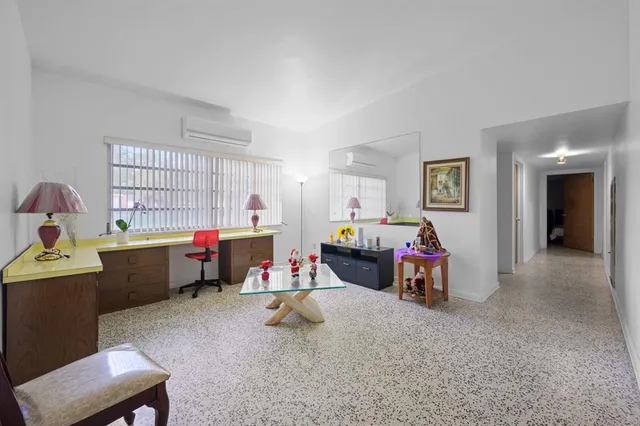 a view of a workspace with furniture and a window