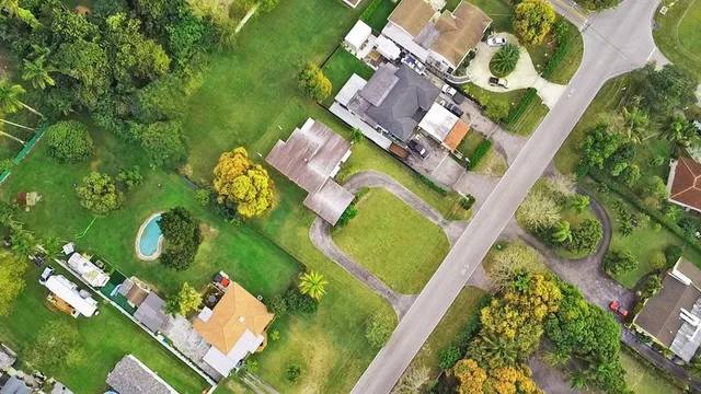 an aerial view of a residential house with outdoor space and a lake view