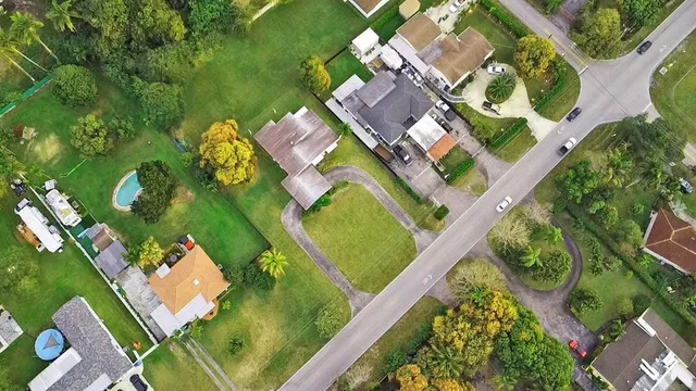 an aerial view of a residential houses with yard