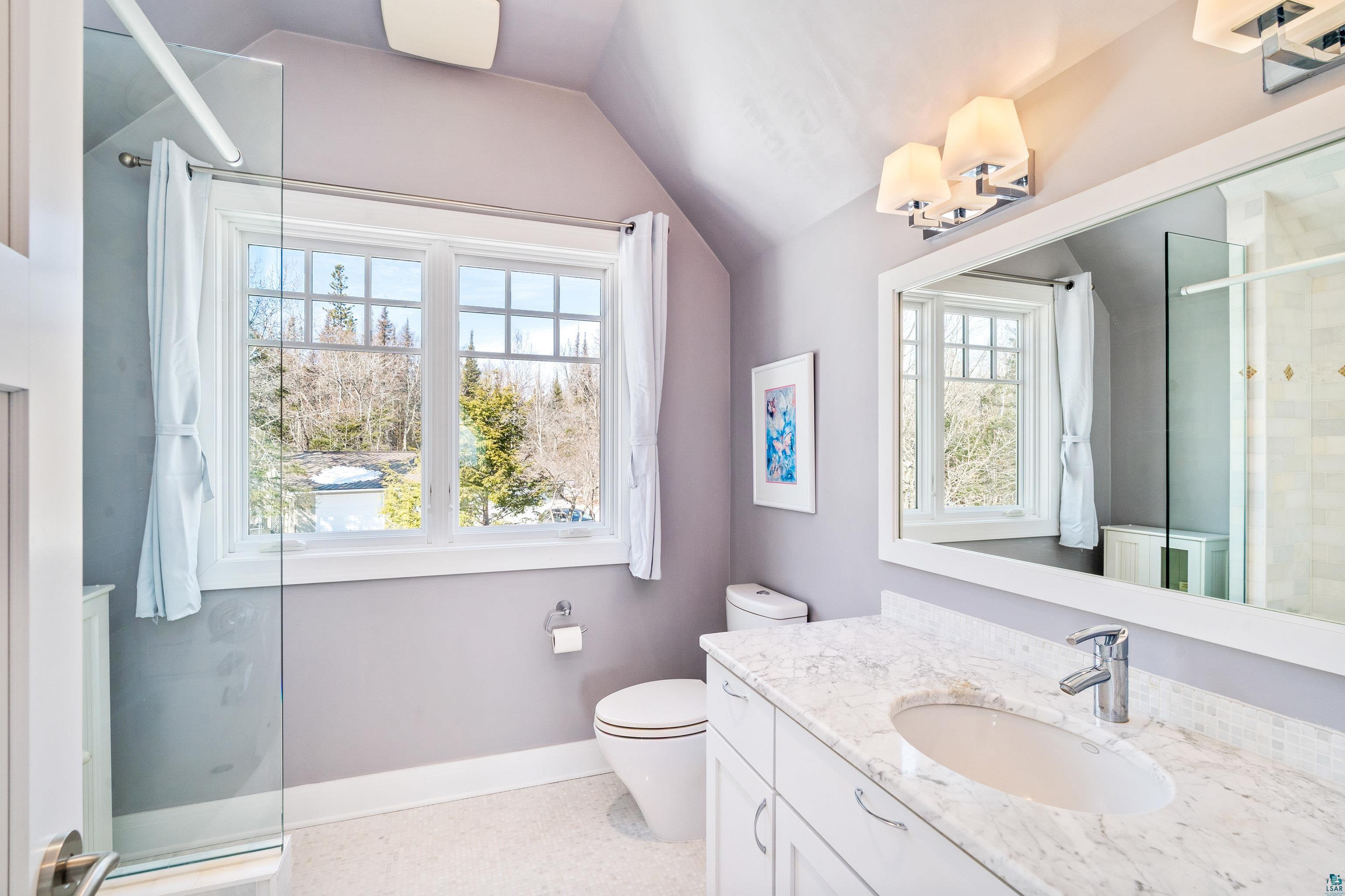 5290 Lakewood Road Duluth, MN 55804 - Photo 27 of 50 Full bath with lofted ceiling, toilet, a shower with shower door, vanity, and baseboards