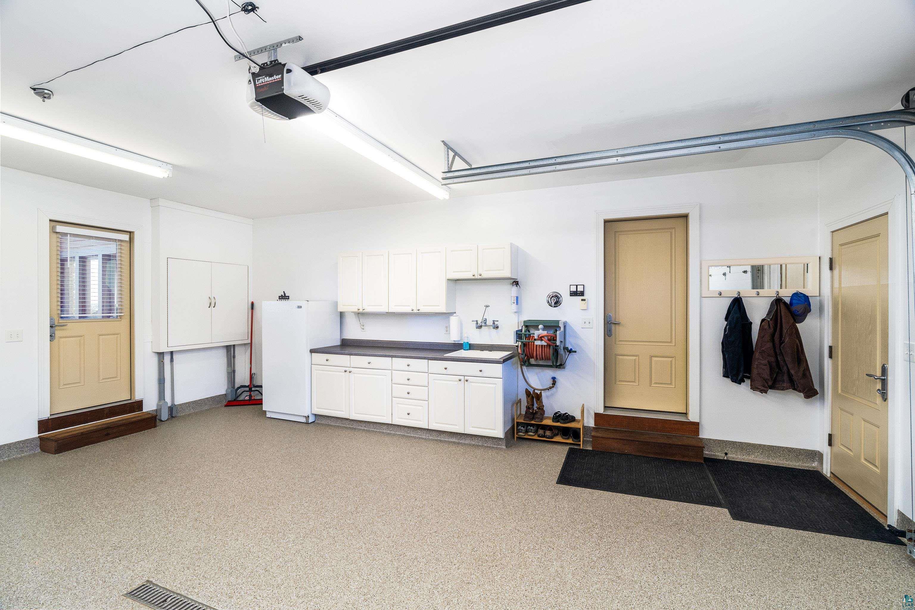 5290 Lakewood Road Duluth, MN 55804 - Photo 41 of 50 Garage featuring baseboards, freestanding refrigerator, utility sink, hot and cold water, and a garage door opener
