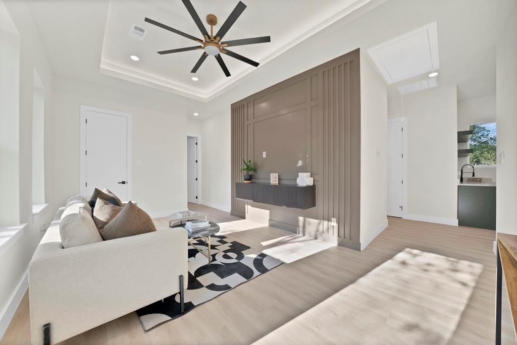 1415 Fayette Street Dallas, TX 75203 - Photo 30 of 40 Recessed lighting, wood-finish flooring, tray ceiling, modern ceiling fan, and accent wall paneling