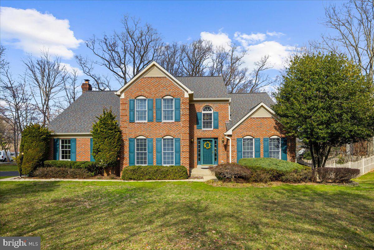 a front view of a house with a garden and trees