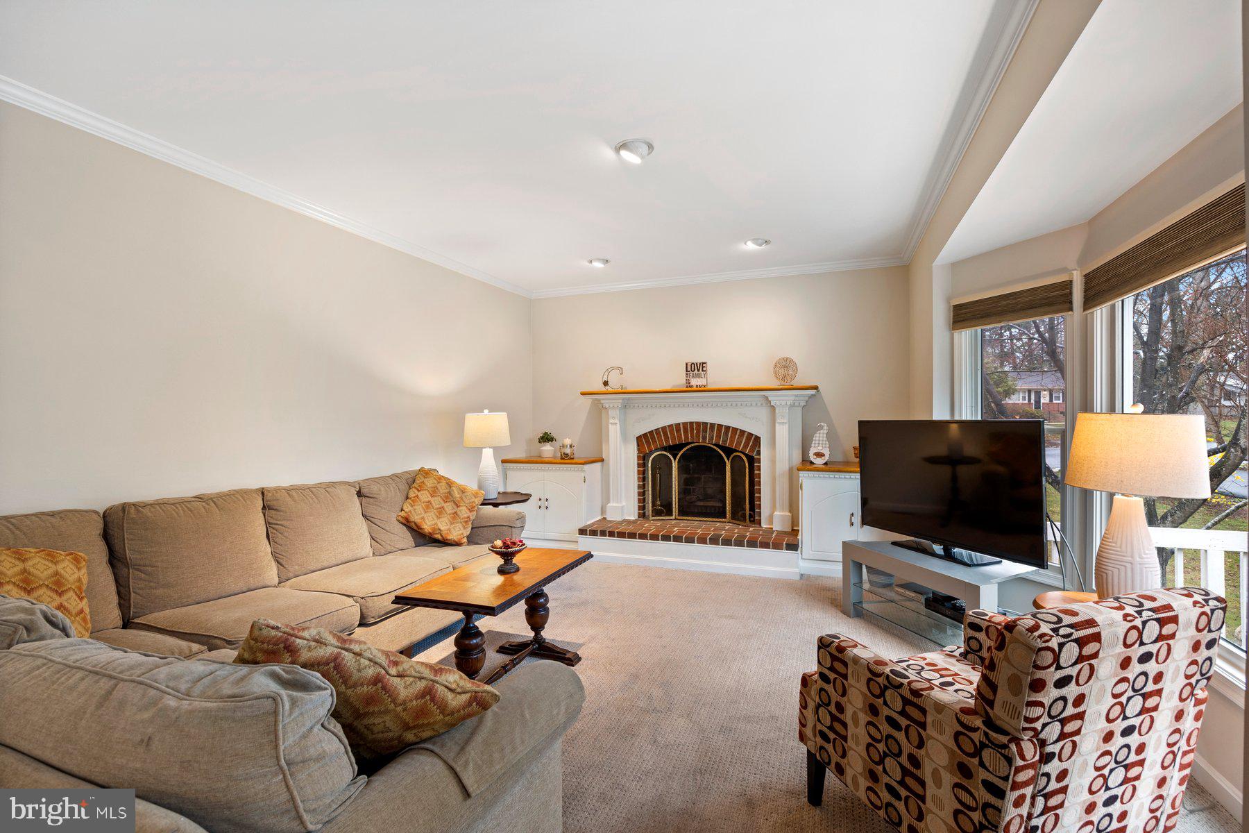 8037 Crest Road Laurel, MD 20723 - Photo 16 of 60 a living room with furniture a flat screen tv and a fireplace