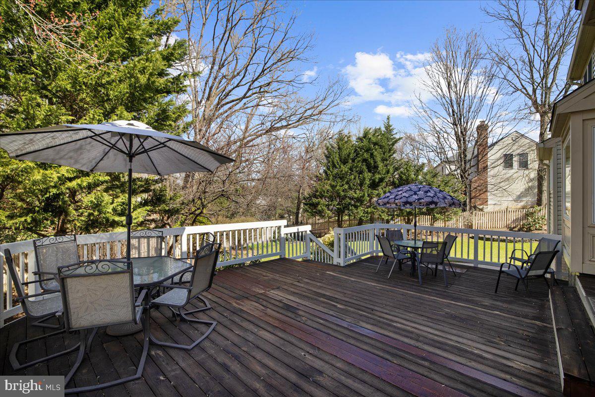 8037 Crest Road Laurel, MD 20723 - Photo 31 of 60 a view of a roof deck with table and chairs under an umbrella with wooden floor