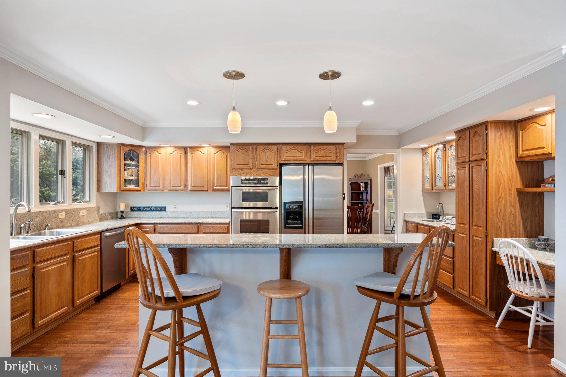 8037 Crest Road Laurel, MD 20723 - Photo 8 of 60 a kitchen with stainless steel appliances granite countertop dining table chairs and wooden floor