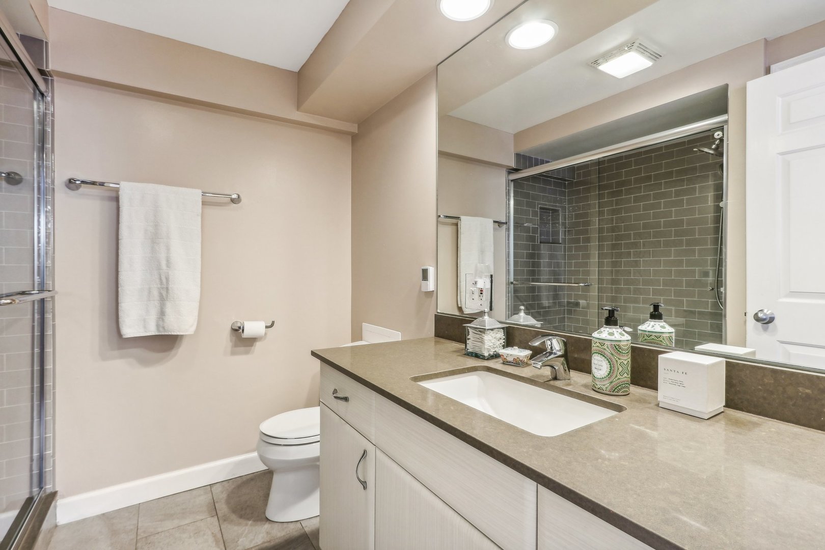 815 Reba Place, Unit 104 Evanston, IL 60202 - Photo 17 of 26 a bathroom with a double vanity sink toilet and a mirror