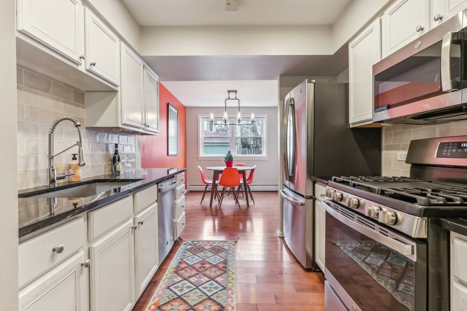 815 Reba Place, Unit 104 Evanston, IL 60202 - Photo 10 of 26 a kitchen with stainless steel appliances granite countertop a stove a sink dishwasher and cabinets with wooden floor