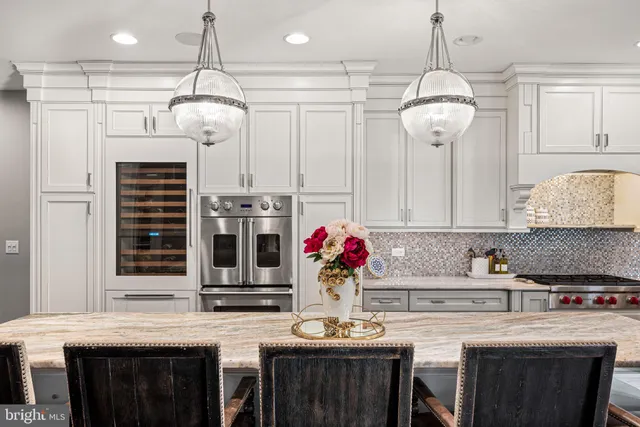 a kitchen with stainless steel appliances granite countertop a stove and a chandelier