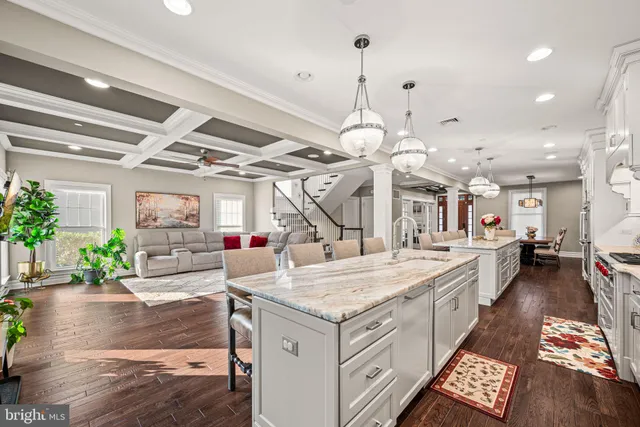 an open kitchen with a sink a oven a counter top space and living room view