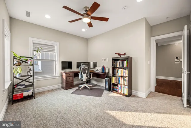 a view of a livingroom with workspace and a window