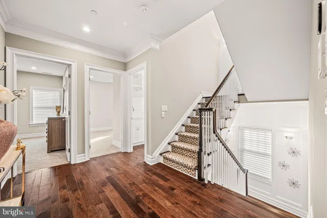 a view of a hallway with wooden floor and staircase