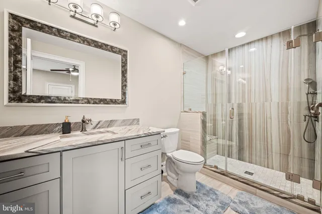 a bathroom with a toilet a sink and glass door