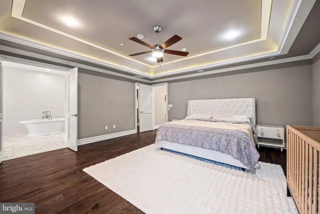 a bedroom with a large bed and wooden floor