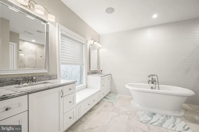 a spacious bathroom with a double vanity sink and a bathtub