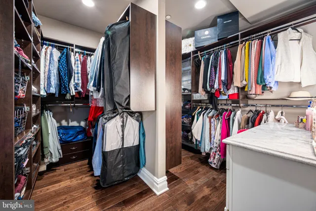 a view of walk in closet with clothes and shoes