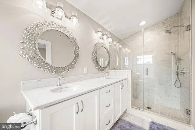 a bathroom with a double vanity sink mirror and shower