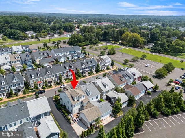 an aerial view of a city with lots of residential buildings and mountain view in back