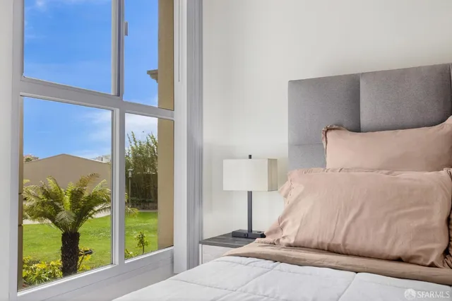 a bedroom with a bed and a lamp next to a window