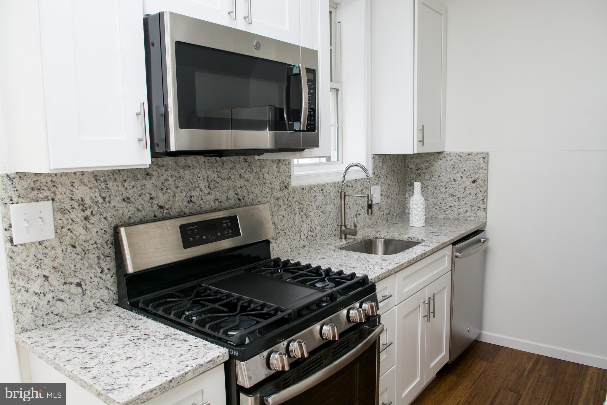 6216 5th Street Northwest Washington, DC 20011 - Photo 8 of 25 a kitchen with stainless steel appliances a stove a microwave and sink