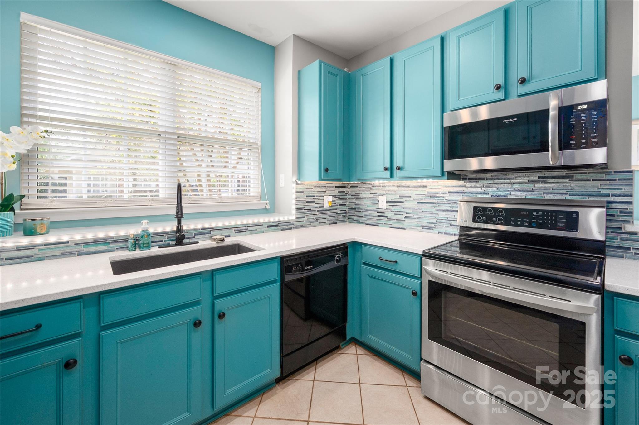 969 Copperstone Lane Fort Mill, SC 29708 - Photo 7 of 36 a kitchen with stainless steel appliances kitchen island a sink a microwave cabinets and a window