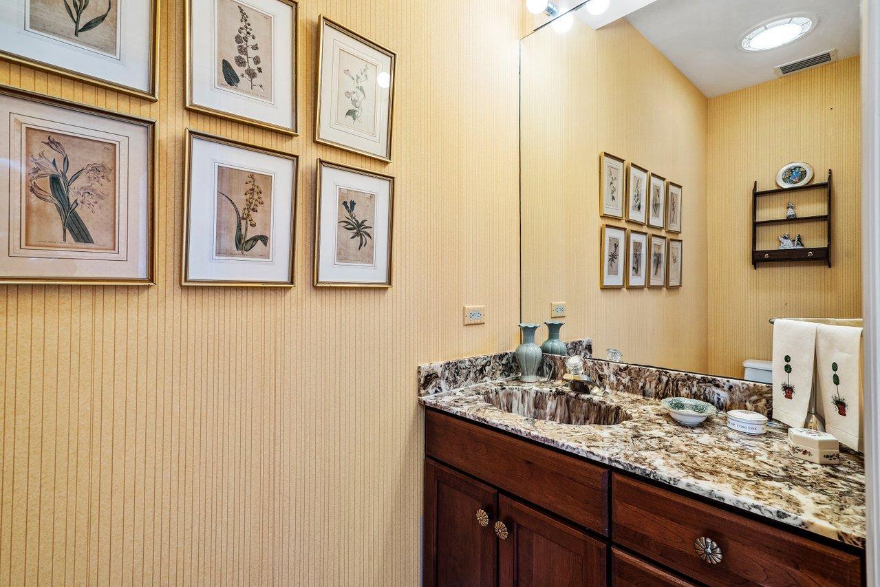 169 Apollo Circle Jupiter, FL 33477 - Photo 35 of 54 a bathroom with a granite countertop sink and a mirror