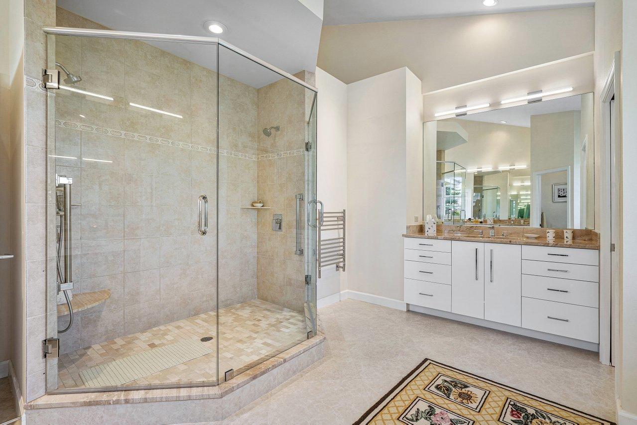 169 Apollo Circle Jupiter, FL 33477 - Photo 40 of 54 a bathroom with a shower sink and mirror