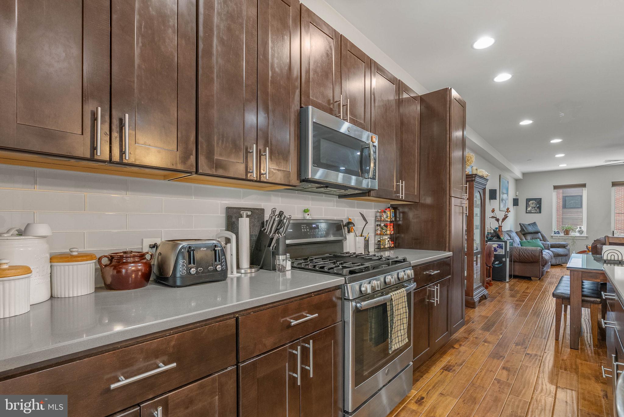 1423 South Howard Street Philadelphia, PA 19147 - Photo 13 of 40 a kitchen with stainless steel appliances granite countertop wooden cabinets a stove top oven a sink and dishwasher