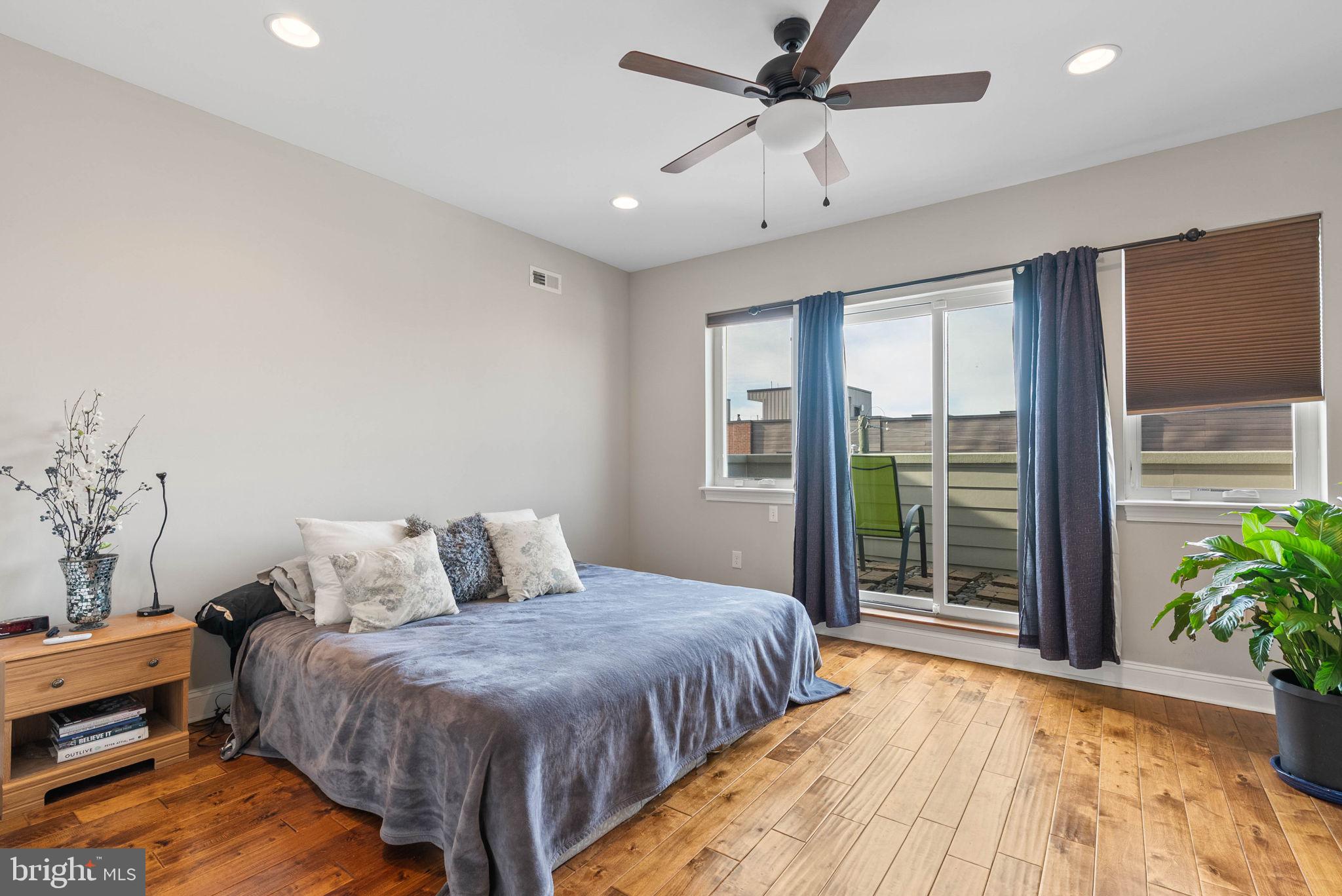1423 South Howard Street Philadelphia, PA 19147 - Photo 32 of 40 a spacious bedroom with a large bed and a potted plant
