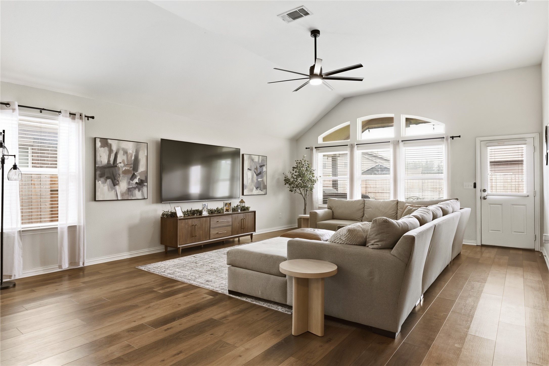 486 Pond View Pass Buda, TX 78610 - Photo 17 of 39 Spacious living area featuring wood-finish flooring, a vaulted ceiling, and an updated ceiling fan