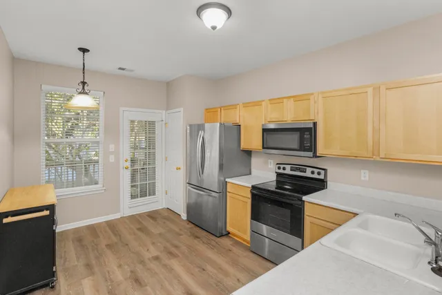 a kitchen with stainless steel appliances granite countertop a stove a sink dishwasher a refrigerator and cabinets with wooden floor