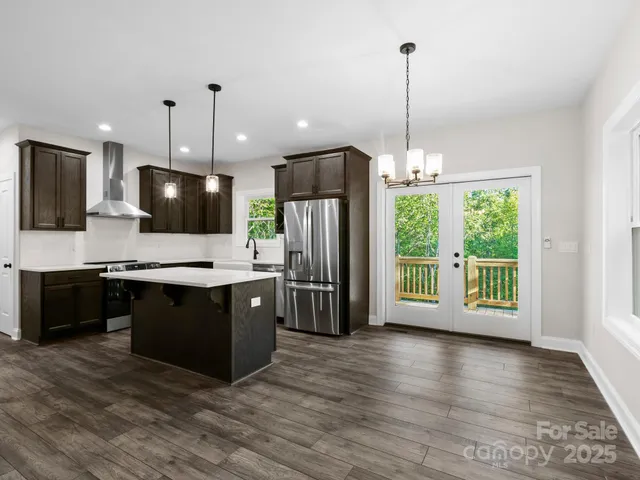 a large kitchen with stainless steel appliances kitchen island granite countertop a large island in the center