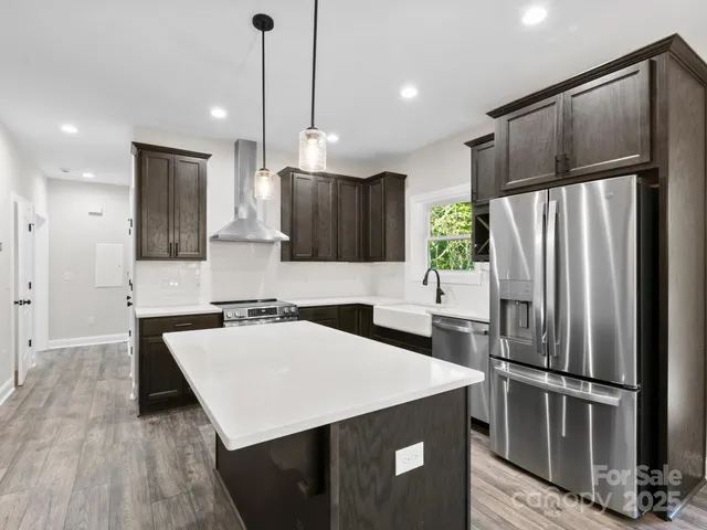 a kitchen with a refrigerator a sink and wooden cabinets