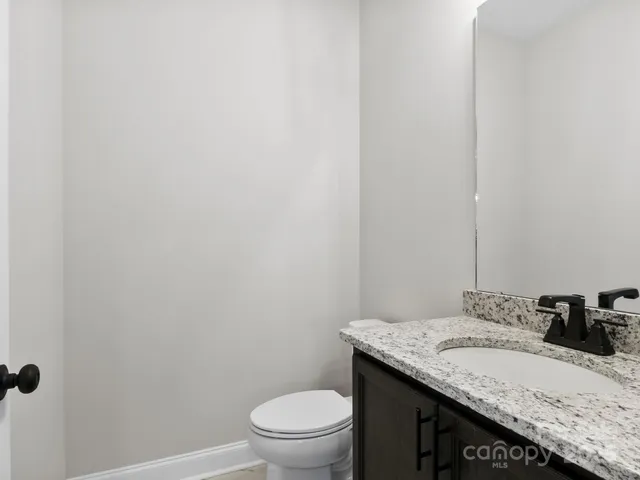 a bathroom with a granite countertop sink toilet a large mirror a bathtub and shower