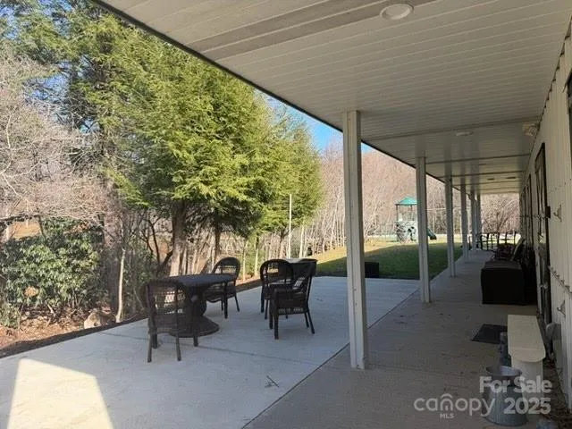 a view of a patio with table and chairs potted plants with large tree