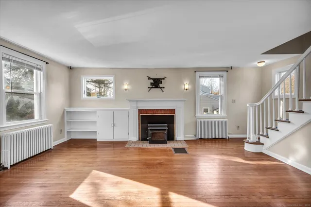 a view of a livingroom with a fireplace wooden floor and windows