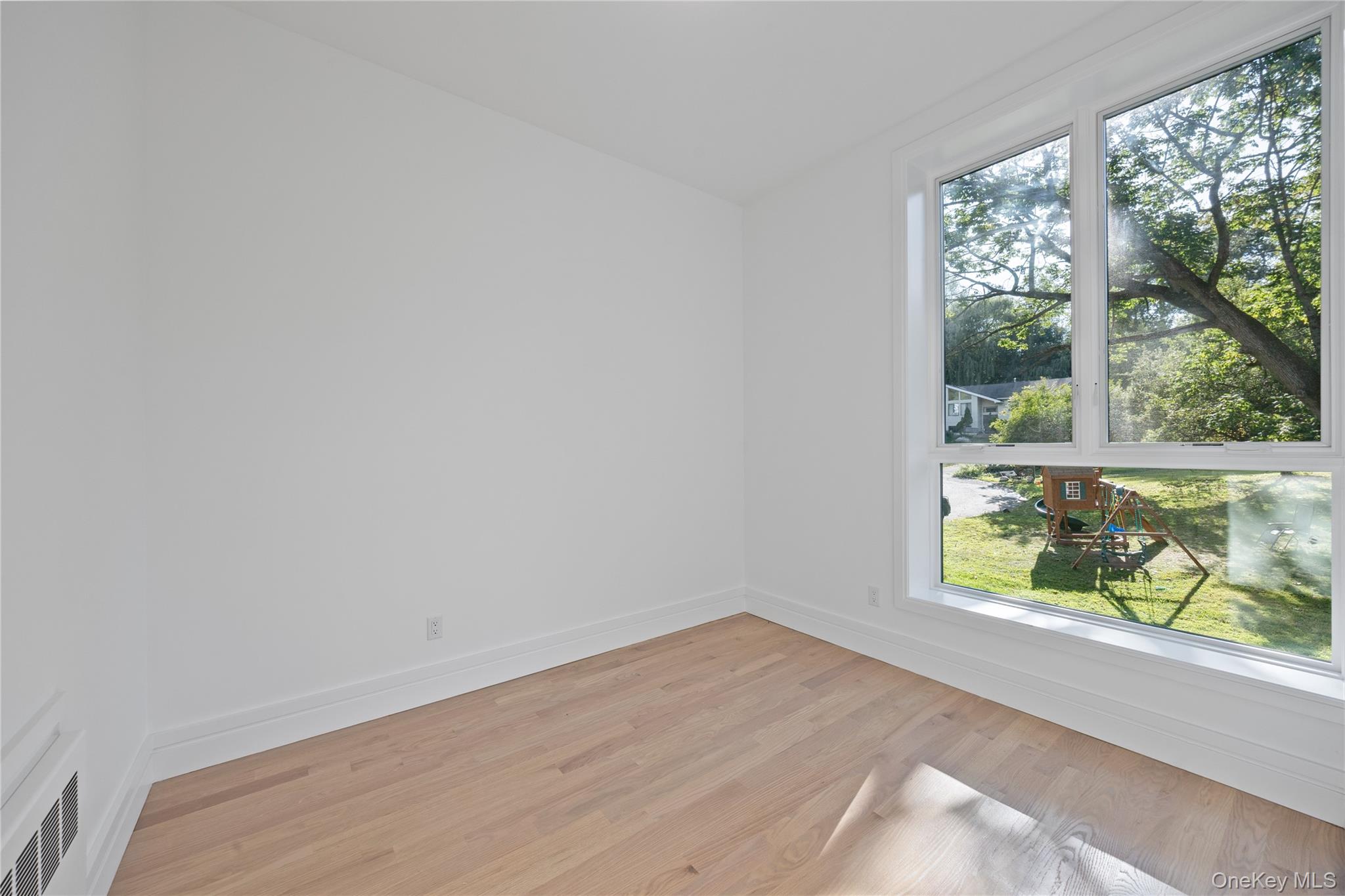 40 Singer Avenue, Unit 214 Spring Valley, NY 10977 - Photo 13 of 49 an empty room with wooden floor and windows