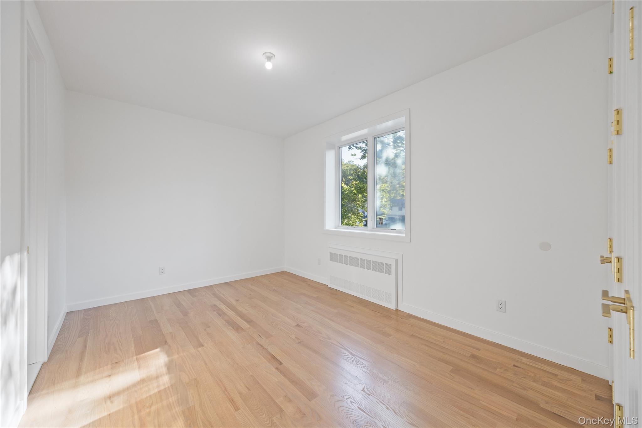 40 Singer Avenue, Unit 214 Spring Valley, NY 10977 - Photo 26 of 49 an empty room with wooden floor and windows
