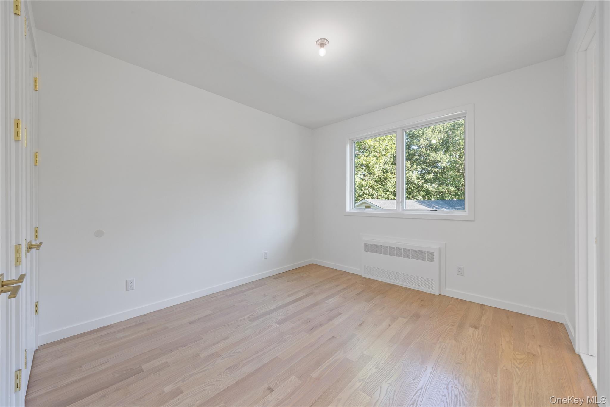 40 Singer Avenue, Unit 214 Spring Valley, NY 10977 - Photo 27 of 49 an empty room with wooden floor and windows