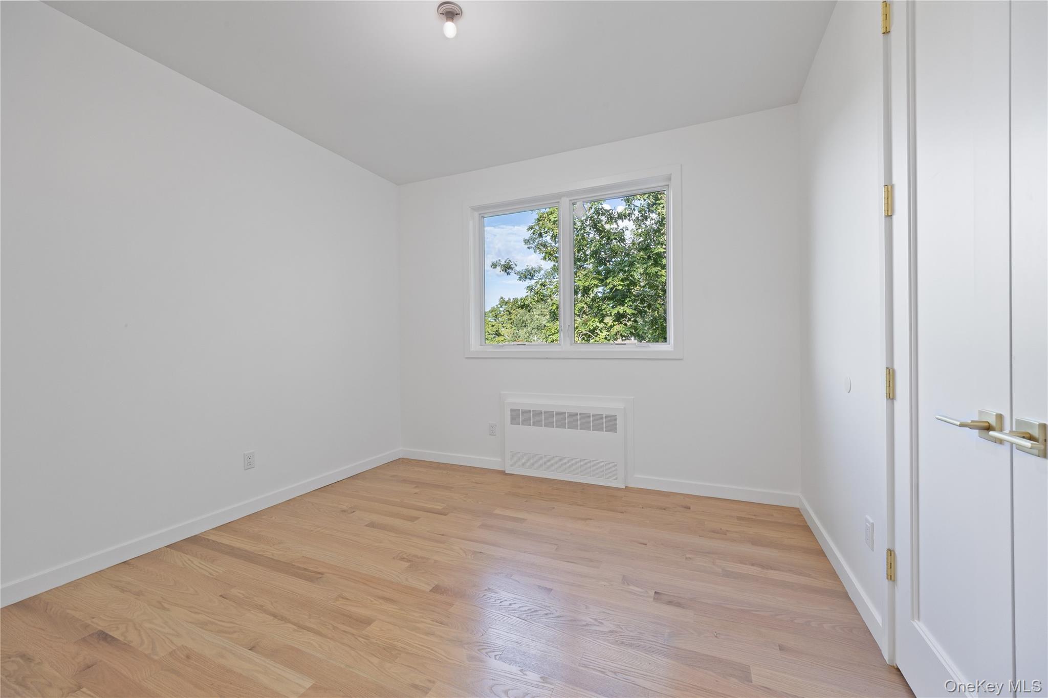 40 Singer Avenue, Unit 214 Spring Valley, NY 10977 - Photo 30 of 49 an empty room with wooden floor and windows